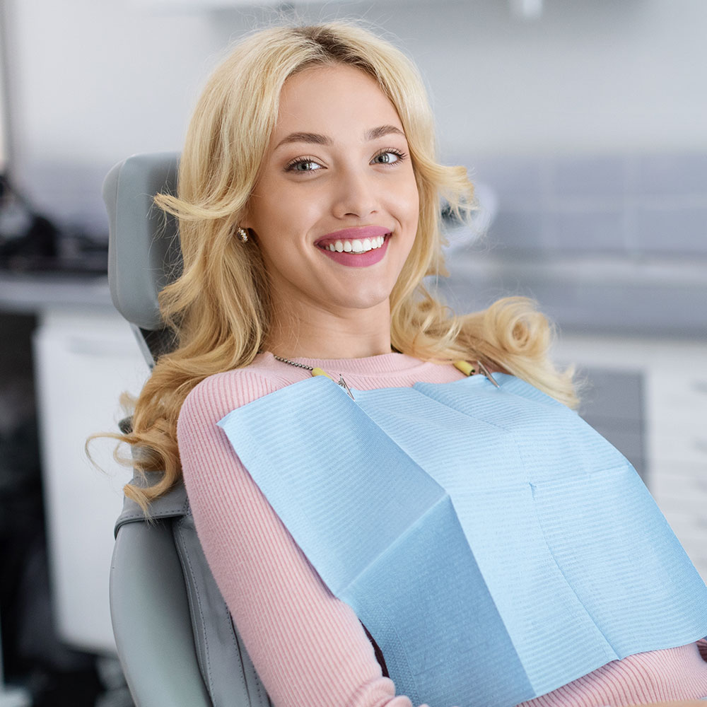 Patient smiling after dental crown repair in Downey